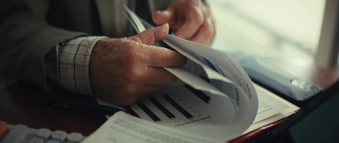 Hands flipping through reports with charts and text