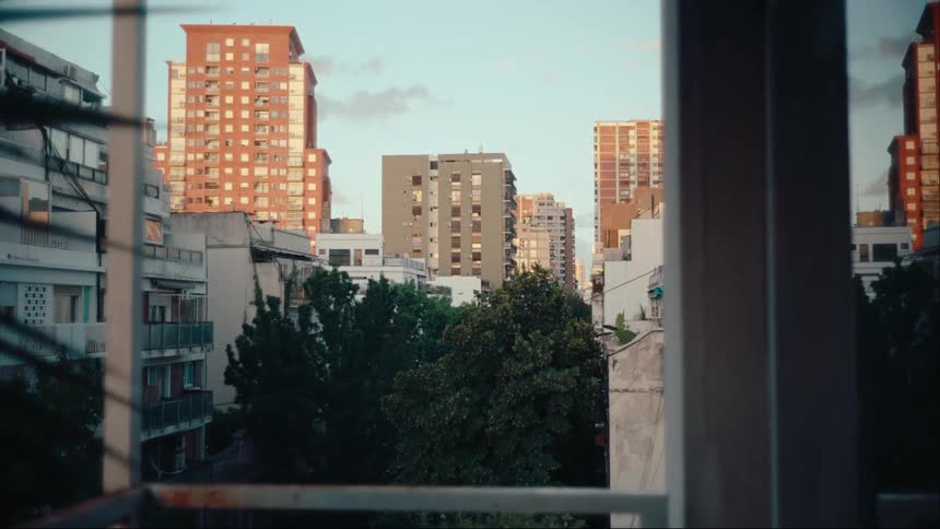 Tall apartment buildings as trees move in the breeze