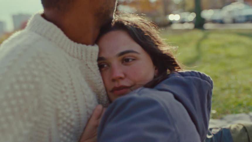 Young adult man and young adult woman talking and hugging on a park in an urban area outdoors during day time