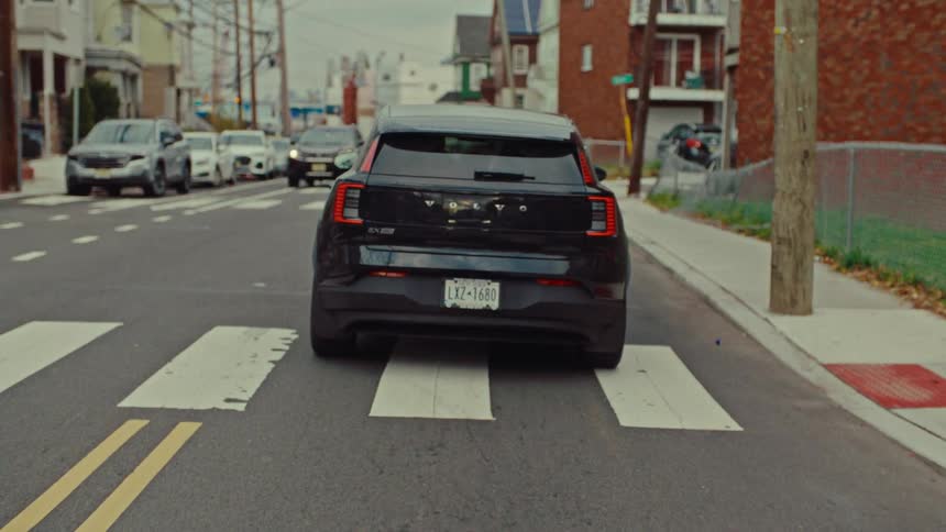 Traffic moves through an intersection in a residential neighborhood on an overcast day