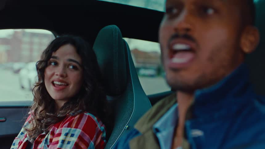 Man and woman singing inside a car