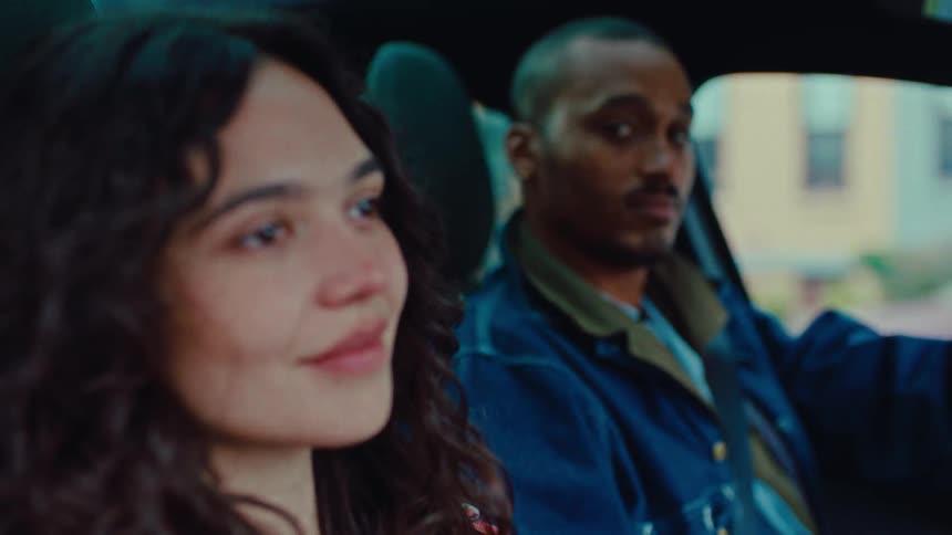 Male driver looks at his female passenger and smiles during the daytime