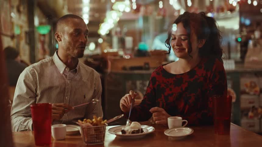 Two people are eating pie in a restaurant