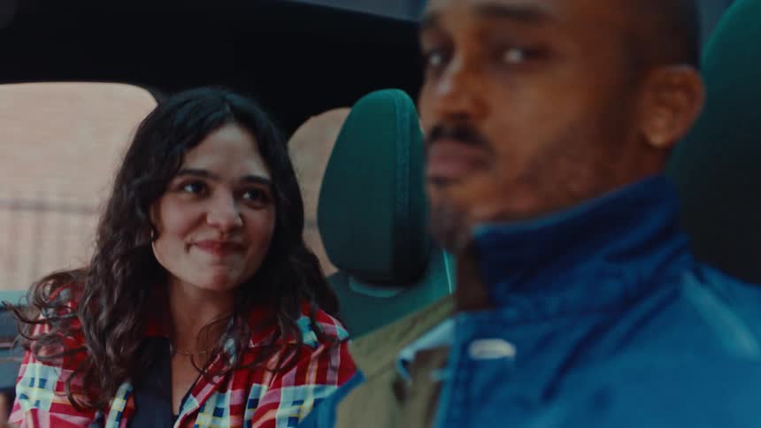 The man drives as the woman sings in the car