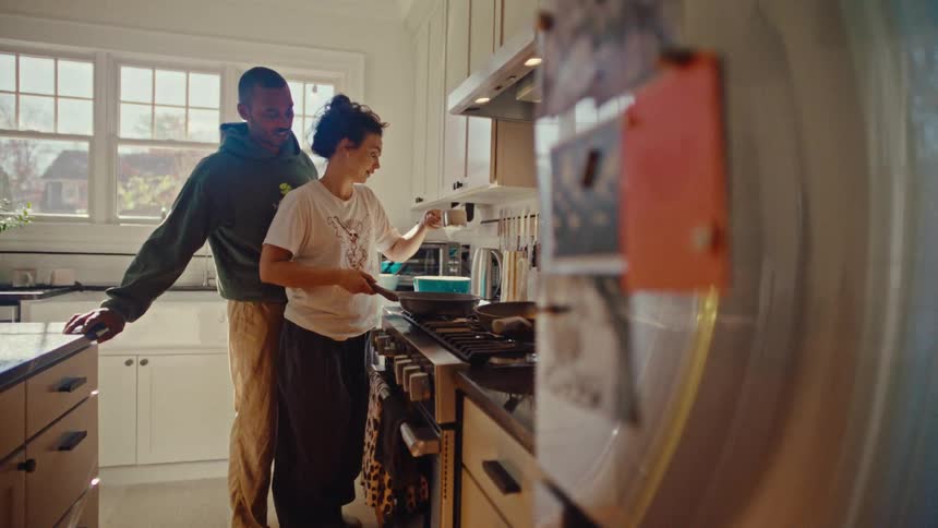 Man and woman cooking together at a kitchen stove