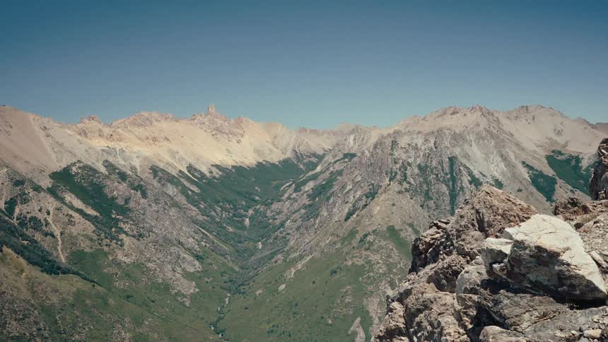 Valley between rocky mountains under a clear sky