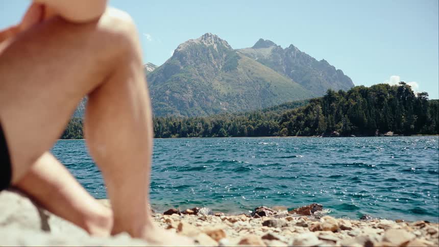 A man resting at the edge of a lake