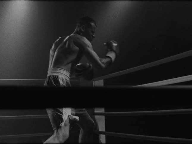 A man is in a boxing ring shadow boxing
