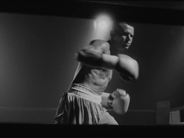 A man boxing in a ring throwing punches