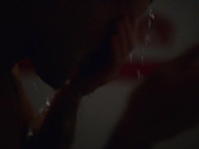 A man rinsing his face in a gym