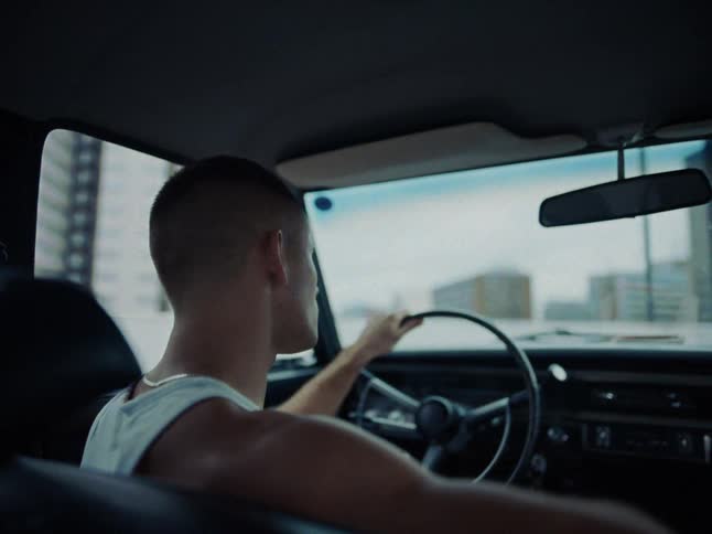 A man sitting in a car in the drivers seat