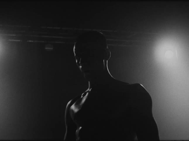 The man is breathing hard and sweating in the boxing ring