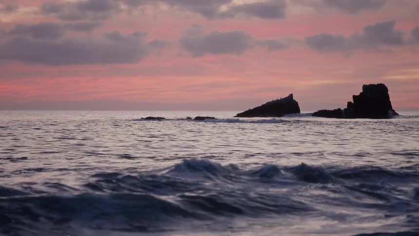 A view of waves on the ocean at sunset