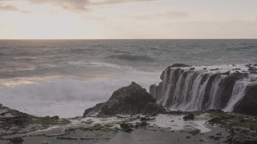 A view of waves crashing into rocks outdoors