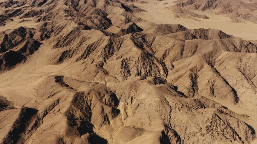 An aerial view of a desert landscape with mountains