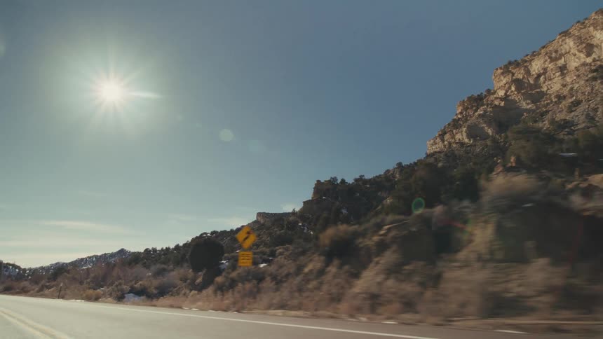 Trees scattered across mountains and rock formations on the roadside