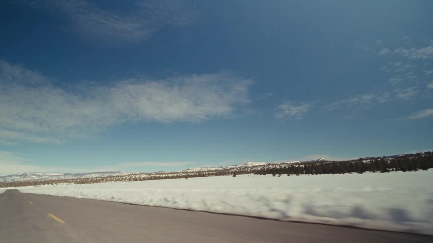 A view of a landscape covered in snow from a highway