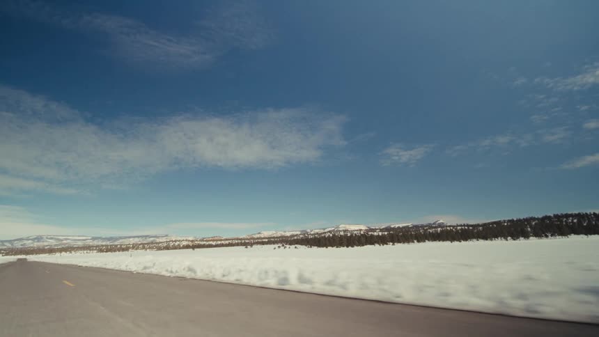 A view of a landscape covered in snow from a highway