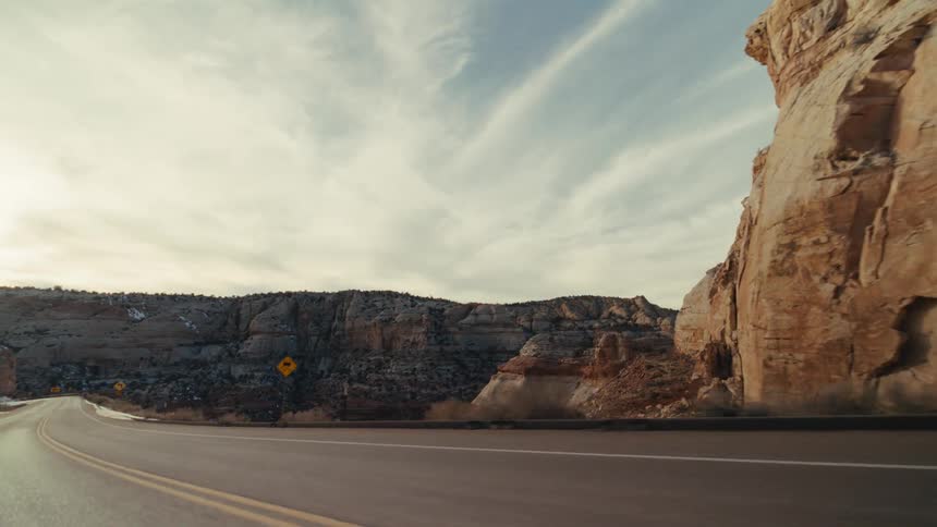 Traveling on a roadway that is lined by a rocky landscape