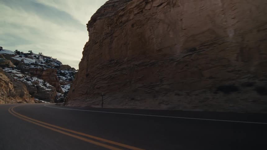Traveling on a roadway that is lined by a rocky landscape