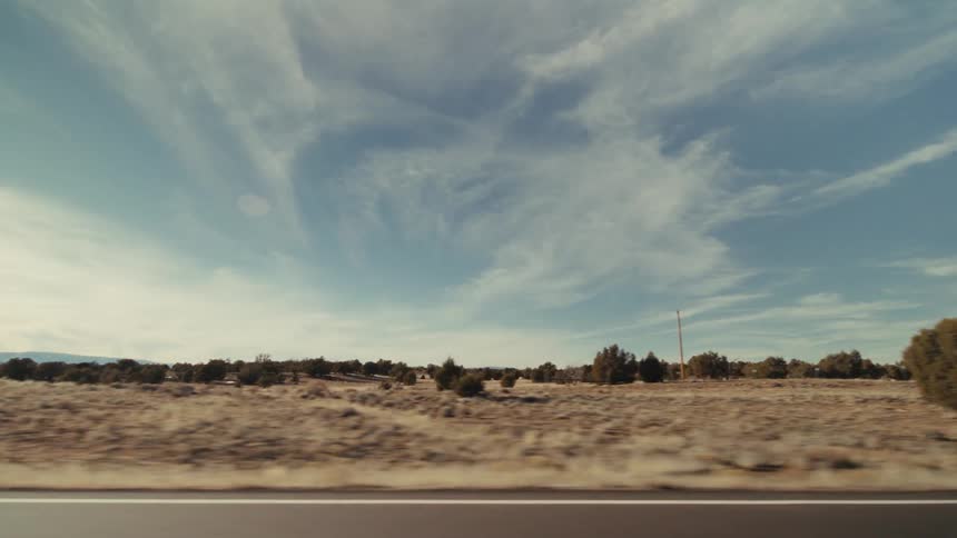 Traveling along a road and the blue sky has clouds stretched across it