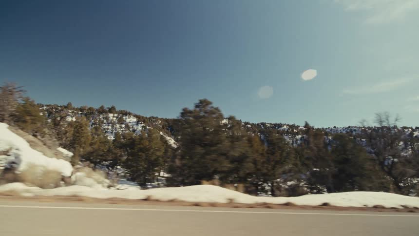 The hills around the highway are covered with snow