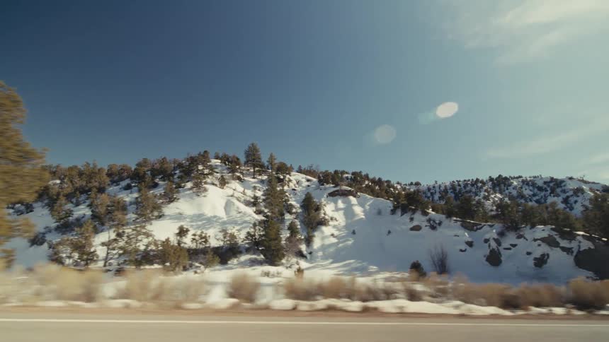The hills around the highway are covered with snow
