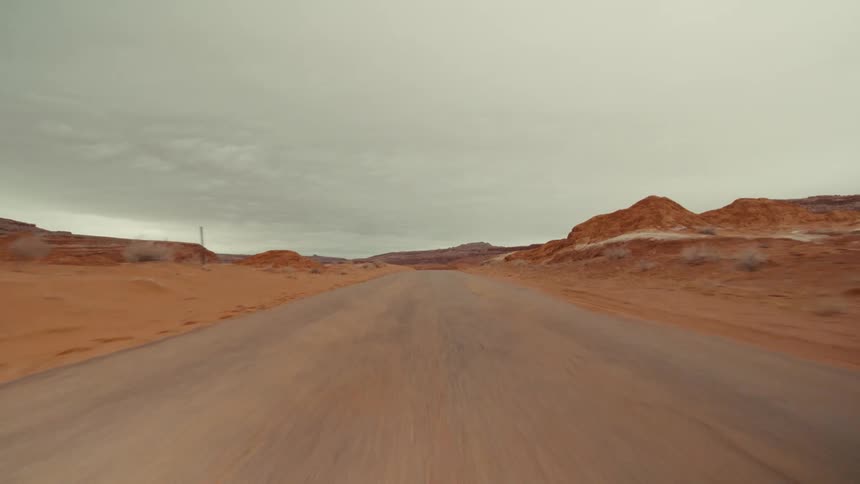 Traveling on a desert road with red rock mountains and canyons