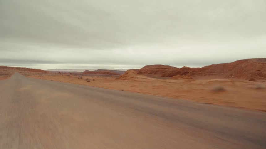 Traveling on a desert road with red rock mountains and canyons
