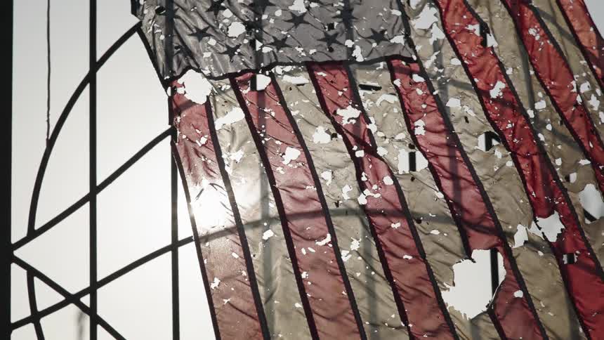 A destroyed tattered flag in a burnt out area