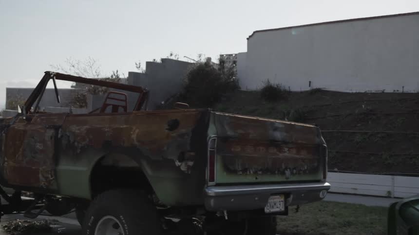 Burned out abandoned truck and trash cans on the street