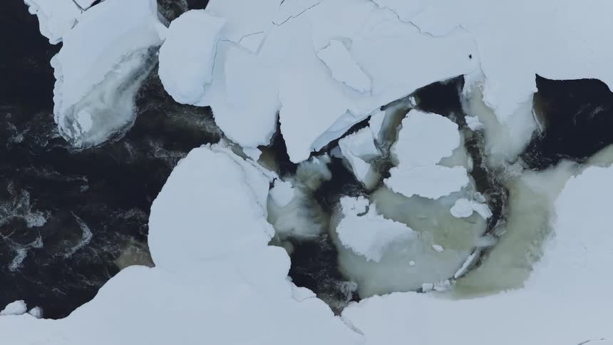 Deep snow covers a flowing creek on a winter day