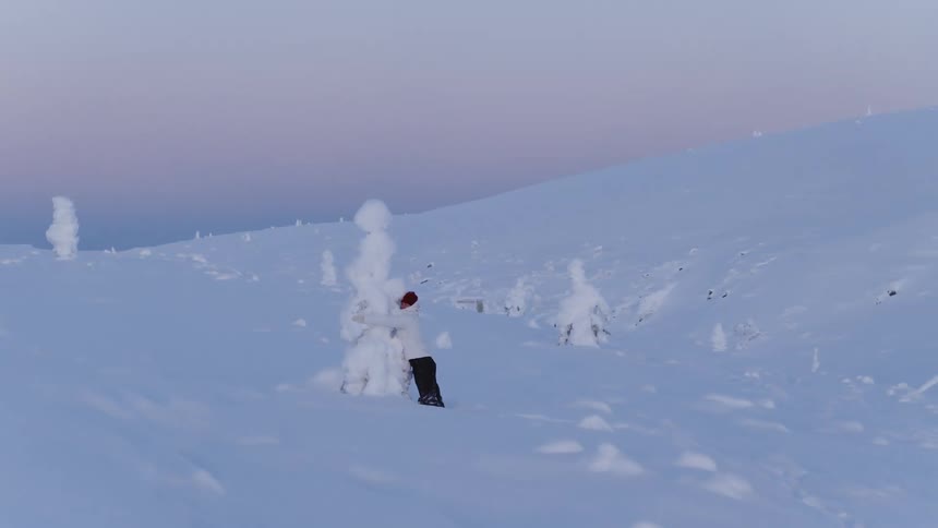 A person next to a tree covered in snow