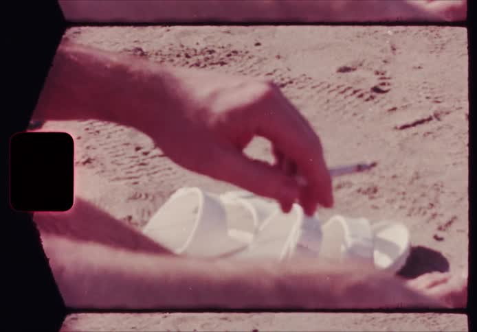 Man sits on the beach smoking during the daytime