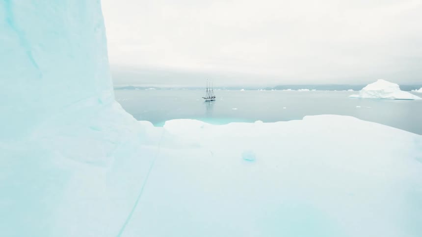 Moving through an ice cave and a boat sailing on arctic water