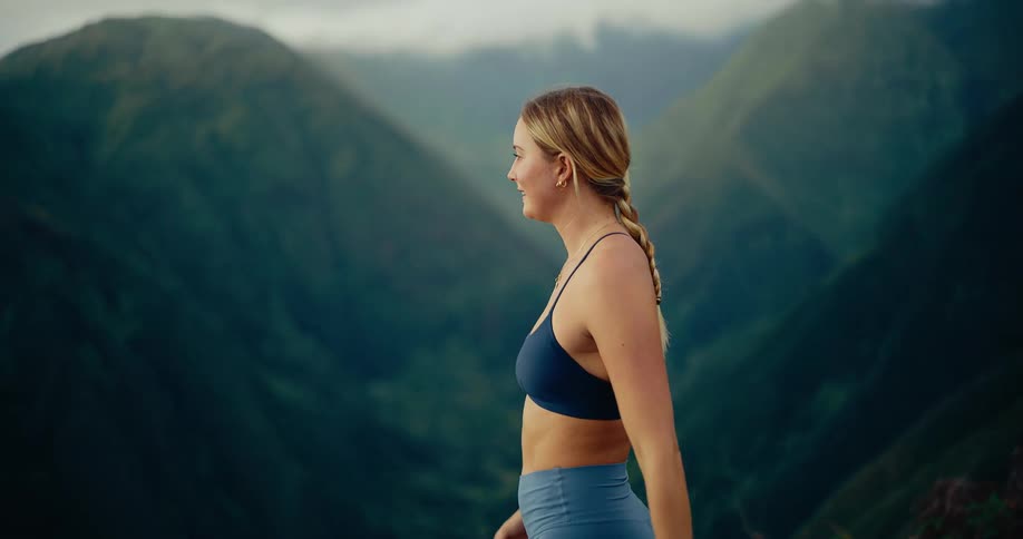 A woman standing at the edge of a mountain