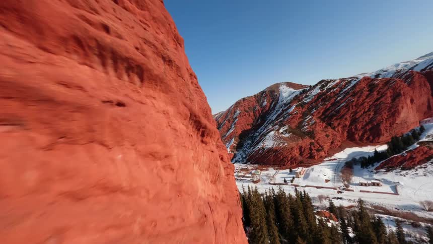 Aerial view of snow on red rock mountain canyons and across the valley