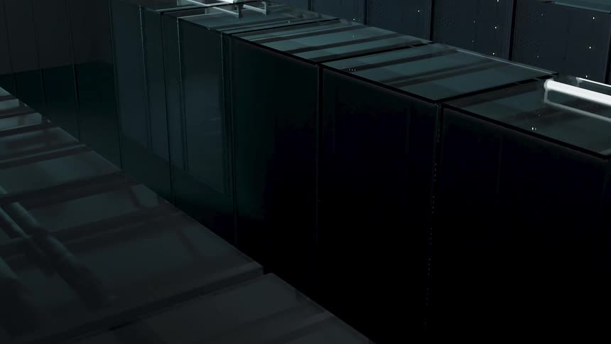 An office with a chair behind a desk and a computer on the desk its screen brightly lit