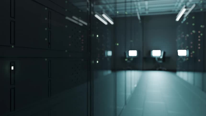 Data center corridor with server racks and illuminated monitors in the background