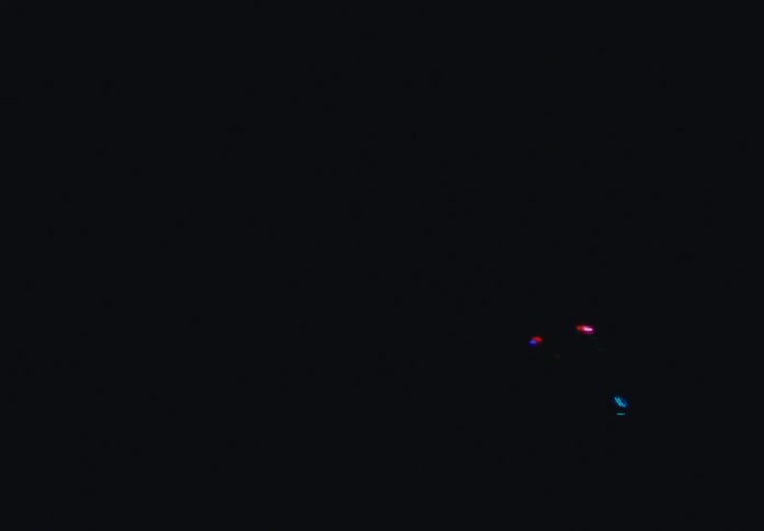 Flashing light illuminates a set containing machines and a screen