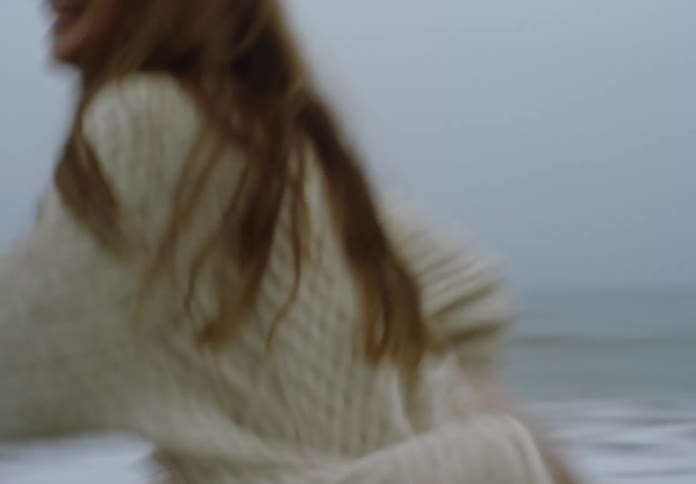 The mother picks up her daughter and runs on the beach