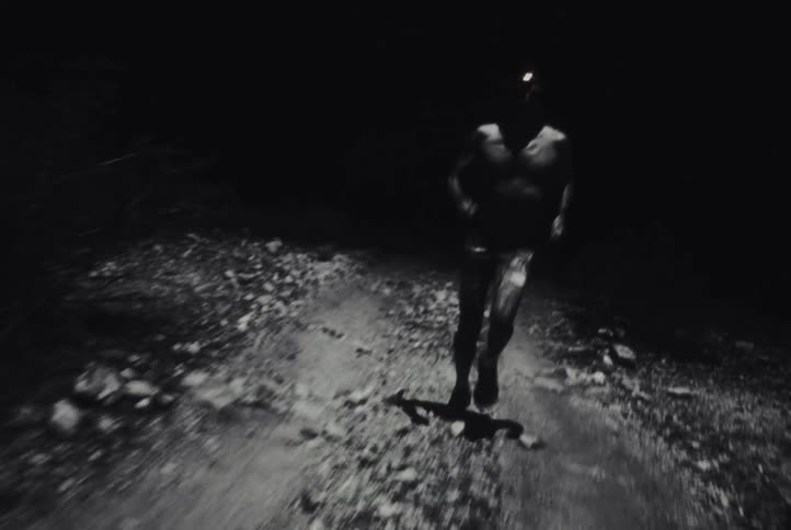 Person runs along a dirt trail at night