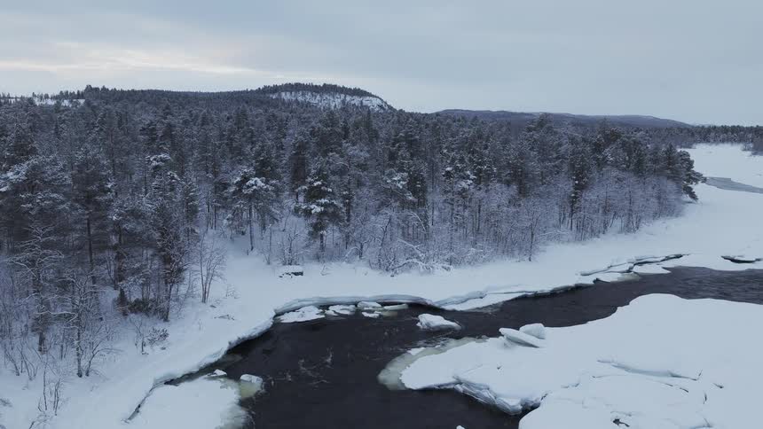 The stream runs past the frozen terrain