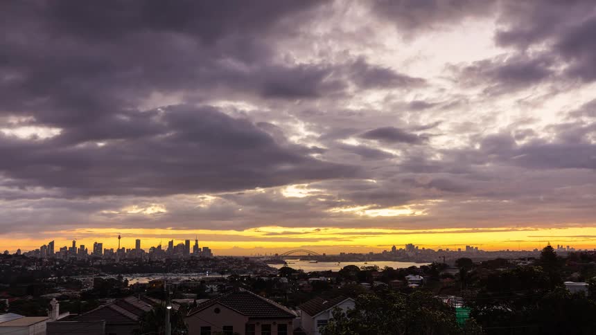 Urban skyline at dusk with cloudy sky lit by the sunset