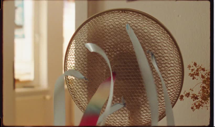Ribbons attached to a fan spinning in a lit indoor environment