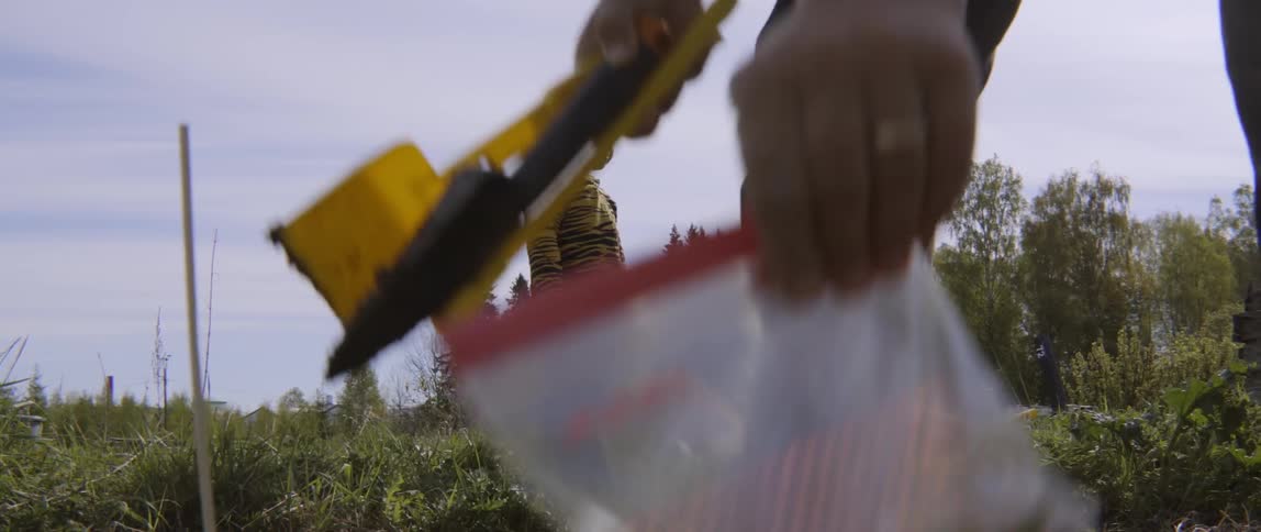 Close up of a mother cleaning a garden spade while playing with toddler.