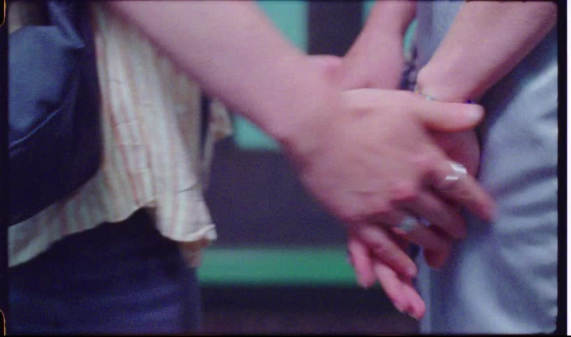 Two people holding hands outdoors