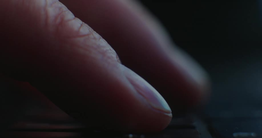 A close up of a two fingers with one tapping on a laptop keyboard with a blurred background