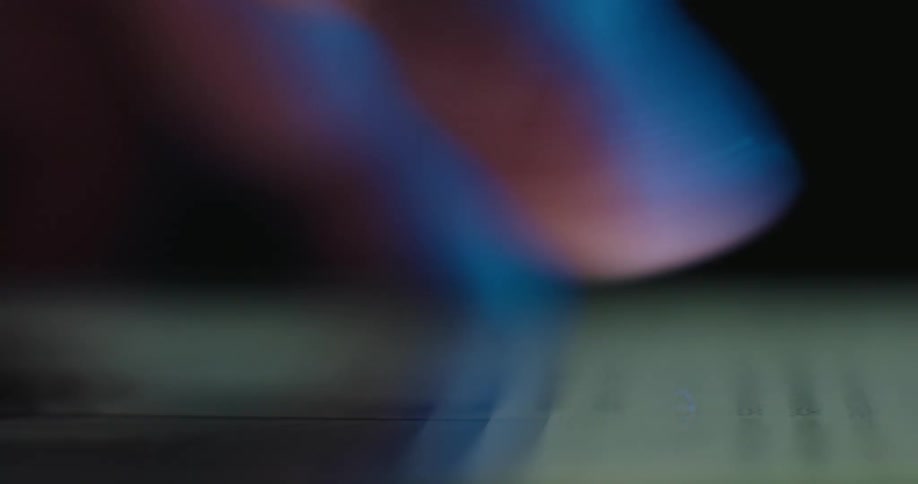A finger scrolls through content on a smartphone screen in a dark environment