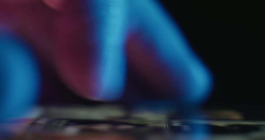 A closeup shallowdepthoffield shot of a persons finger scrolling through a grid of images on a smartphone screen the scene is illuminated with cool blue and warm orange light highlighting the texture of the skin as it moves across the glass